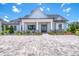 Stunning front exterior of the home, showcasing a welcoming porch, well-maintained landscaping, and a paver driveway at 12902 Sw 138Th Loop, Dunnellon, FL 34432