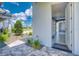 View from the exterior of an open garage entrance; manicured landscaping and blue skies fill the background at 12902 Sw 138Th Loop, Dunnellon, FL 34432