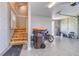 Spacious garage with stairs leading up to an unfinished storage space, offering room for customizations at 12902 Sw 138Th Loop, Dunnellon, FL 34432