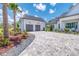 A bright, white, two-car detached garage alongside the house and front yard, showcasing a paver driveway at 12902 Sw 138Th Loop, Dunnellon, FL 34432