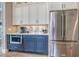 Modern kitchen with stainless steel fridge, custom cabinetry, and stylish mosaic backsplash at 12902 Sw 138Th Loop, Dunnellon, FL 34432