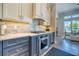 Modern kitchen featuring stainless steel appliances, mosaic backsplash, and two-tone cabinets at 12902 Sw 138Th Loop, Dunnellon, FL 34432