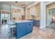 Modern kitchen boasts a large island with seating, blue cabinets, and stylish lighting at 12902 Sw 138Th Loop, Dunnellon, FL 34432