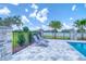 Outdoor pool area features stone pavers, a safety fence and lounge chairs overlooking the water at 12902 Sw 138Th Loop, Dunnellon, FL 34432