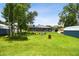 Sprawling backyard features a screened pool and patio, firepit, lush green grass, and outbuildings at 3229 Gardner Oaks Ln, Lakeland, FL 33810