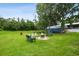 Lush backyard with an outbuilding, a stone firepit area, benches, and mature trees at 3229 Gardner Oaks Ln, Lakeland, FL 33810