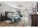 This spacious bedroom features wood-look tile, a ceiling fan, and French doors to the outside at 3229 Gardner Oaks Ln, Lakeland, FL 33810