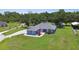 Lovely blue home featuring lush lawn, colorful landscaping, and long concrete driveway at 3229 Gardner Oaks Ln, Lakeland, FL 33810
