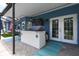 A covered outdoor bar and lounge area with patio furniture and a view of the screened pool and outdoor kitchen at 3229 Gardner Oaks Ln, Lakeland, FL 33810