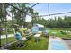 Outdoor screened pool area with comfortable seating, lush landscaping, and an inviting fire pit at 3229 Gardner Oaks Ln, Lakeland, FL 33810