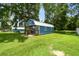 Charming blue shed on lush green lawn with covered porch at 3229 Gardner Oaks Ln, Lakeland, FL 33810