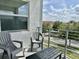 Outdoor balcony with comfortable seating and a table, perfect for enjoying the view of the neighborhood at 4751 Clock Tower Dr # 307, Kissimmee, FL 34746