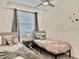 Cozy bedroom featuring two twin beds, soft linens, a bedside table, and a window bringing in natural light at 4751 Clock Tower Dr # 307, Kissimmee, FL 34746