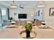 Bright dining area with modern lighting, a dining table with six places, and a view of the outdoor living space at 4751 Clock Tower Dr # 307, Kissimmee, FL 34746