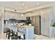 Modern kitchen with stainless steel appliances, a breakfast bar, and sleek white cabinetry at 4751 Clock Tower Dr # 307, Kissimmee, FL 34746