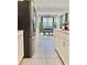 Modern kitchen with stainless steel appliances, tile flooring, white cabinetry, and a view into the dining area at 4751 Clock Tower Dr # 307, Kissimmee, FL 34746