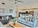 Open living space with plush seating, ceiling fan, and seamless transition to the modern kitchen at 4751 Clock Tower Dr # 307, Kissimmee, FL 34746