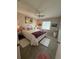 Cozy bedroom with a queen bed, ceiling fan, tropical-themed decor, and carpeted floors at 17569 Se 107Th Ct, Summerfield, FL 34491