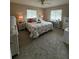 Bedroom with a queen bed, white furniture, and large windows, creating a bright and airy ambiance at 17569 Se 107Th Ct, Summerfield, FL 34491