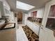 Galley kitchen featuring white cabinets and appliances, with a neutral countertop and tile flooring at 17569 Se 107Th Ct, Summerfield, FL 34491