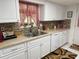 Bright kitchen featuring white cabinetry, stainless steel sink and modern appliances at 17569 Se 107Th Ct, Summerfield, FL 34491