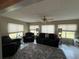 Cozy living room featuring plush furniture, a ceiling fan, and bright natural light from large windows at 17569 Se 107Th Ct, Summerfield, FL 34491