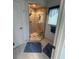 Glass-enclosed shower with built-in bench, complemented by blue accents and modern fixtures at 17569 Se 107Th Ct, Summerfield, FL 34491