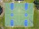 Aerial shot of a fenced basketball court with four blue and green full-sized courts at 297 Beacon Pointe Dr, Ocoee, FL 34761