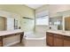 Bathroom featuring a soaking tub, separate vanities, and a window for natural light at 297 Beacon Pointe Dr, Ocoee, FL 34761