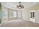 Spacious bedroom with neutral carpeting, tray ceiling, and a fan for added comfort at 297 Beacon Pointe Dr, Ocoee, FL 34761