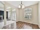 Well-lit dining room featuring hardwood floors, a hanging light fixture, and large windows at 297 Beacon Pointe Dr, Ocoee, FL 34761