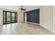 Spacious living room featuring tile flooring, dark accent wall, and french doors at 297 Beacon Pointe Dr, Ocoee, FL 34761