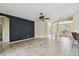 Open-concept living area with tiled floors, dark accent wall, and modern ceiling fan at 297 Beacon Pointe Dr, Ocoee, FL 34761