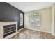 Cozy living room with a fireplace, wood floors, and two windows with blinds at 297 Beacon Pointe Dr, Ocoee, FL 34761