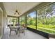 A screened patio with table and chairs offers outdoor dining with beautiful views at 297 Beacon Pointe Dr, Ocoee, FL 34761