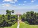 Scenic waterfront view featuring a wooden walkway leading to a charming gazebo surrounded by lush greenery at 297 Beacon Pointe Dr, Ocoee, FL 34761