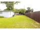View of backyard and side of home with lush lawn and privacy fence at 5 Moonlight Ln, Winter Haven, FL 33884