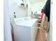 Functional laundry room with washer, dryer, storage shelf, and water heater for convenience at 5 Moonlight Ln, Winter Haven, FL 33884
