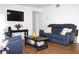 Comfortable living room featuring plush blue furniture, a dark wood table, and a mounted television at 5 Moonlight Ln, Winter Haven, FL 33884