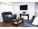 Inviting living room with blue leather sofas, a dark wood coffee table, and a modern mounted TV at 5 Moonlight Ln, Winter Haven, FL 33884