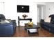 Cozy living room with blue reclining seating, dark wood accents, and a modern mounted TV at 5 Moonlight Ln, Winter Haven, FL 33884