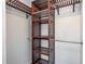 Walk-in closet with dark wood organizers and metal hanging rods at 89 Fremont Ave # 504, Daytona Beach, FL 32114