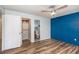 Bedroom with hardwood floors, a blue accent wall and connected bath and closet at 89 Fremont Ave # 504, Daytona Beach, FL 32114