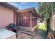 Patio with a grill overlooking the yard and screened porch with palm trees nearby at 89 Fremont Ave # 504, Daytona Beach, FL 32114