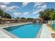 Community swimming pool with lounge chairs, table with chairs and clear blue sky at 89 Fremont Ave # 504, Daytona Beach, FL 32114