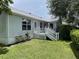 Home's rear view featuring a cozy back porch and well-kept lawn at 508 Alcazar Ct, Lady Lake, FL 32159