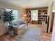 Comfortable living room with a sofa, built-in bookshelves, and plenty of natural light from the windows at 508 Alcazar Ct, Lady Lake, FL 32159