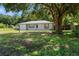 Charming single-story home with a well-maintained lawn and mature tree providing ample shade at 13449 Ashley Ct, Grand Island, FL 32735