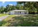Charming single-story home with a well-maintained lawn, attached garage, and mature trees shading the front at 13449 Ashley Ct, Grand Island, FL 32735