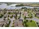 Neighborhood aerial showing houses with well-manicured lawns, solar panels, and a scenic lake backdrop at 16324 Brisk Breeze Aly, Winter Garden, FL 34787